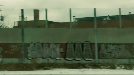 window shot of graffiti murals and urban scenery on a speeding train