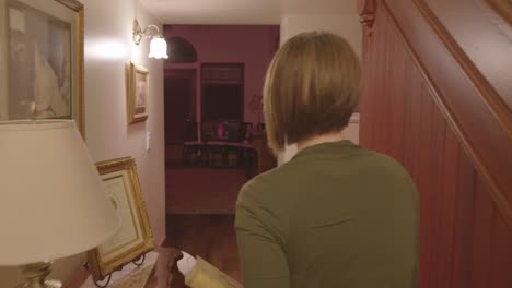 a woman is seen walking down a stair case and turns around to see if someone is there