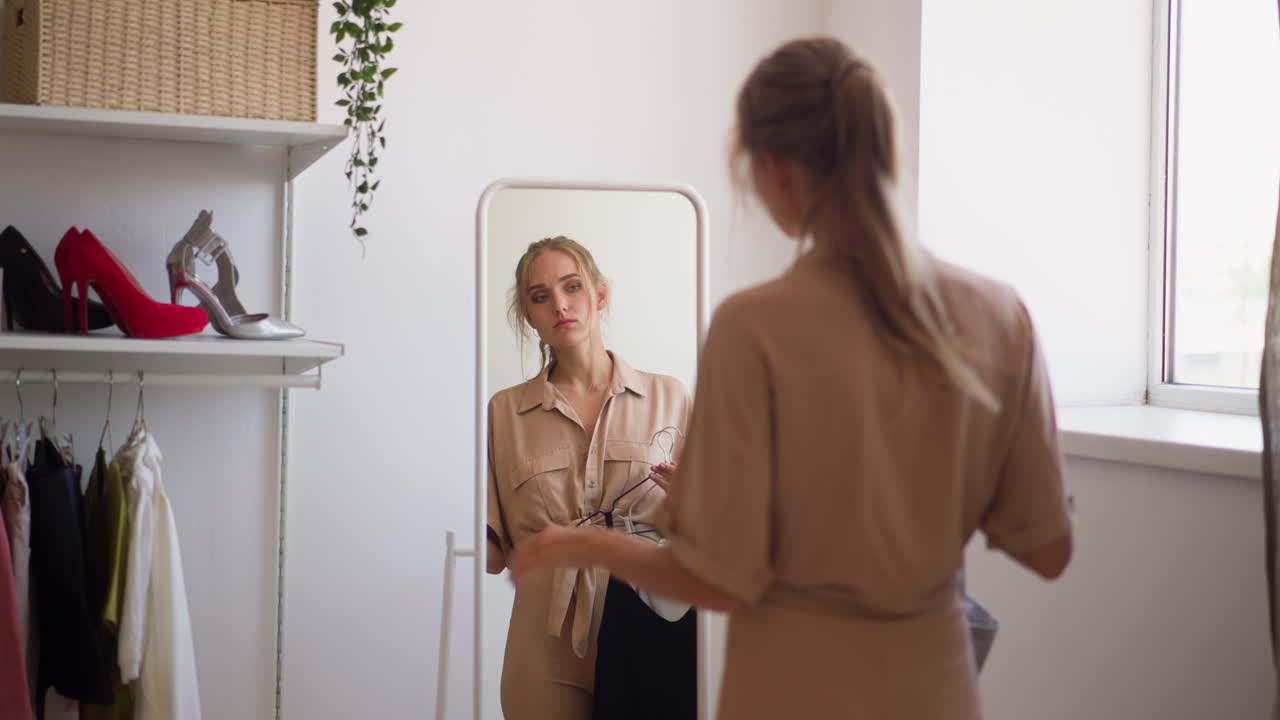 Donna sta davanti allo specchio con dei vestiti per la festa