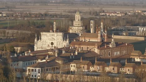 A-drone-footage-over-Certosa-di-Pavia-monastery-with-lawn-fields-in-Italy,-Pavia-shot-at-60-fps