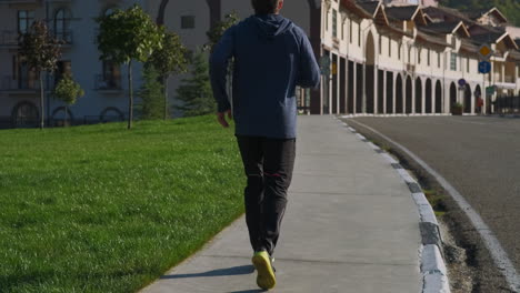 man running on sidewalk in urban park