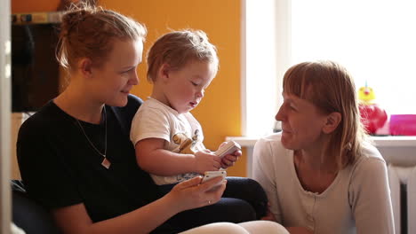 Two-year-old-boy-plays-with-his-mother-and-grandmother