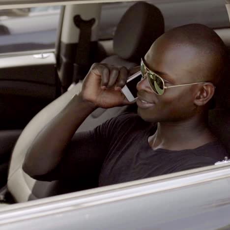 man talking on phone while seated in car