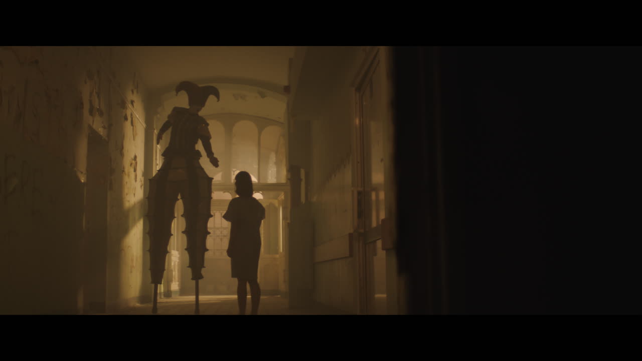 A girl and strange clown on stilts in a dark corridor at night