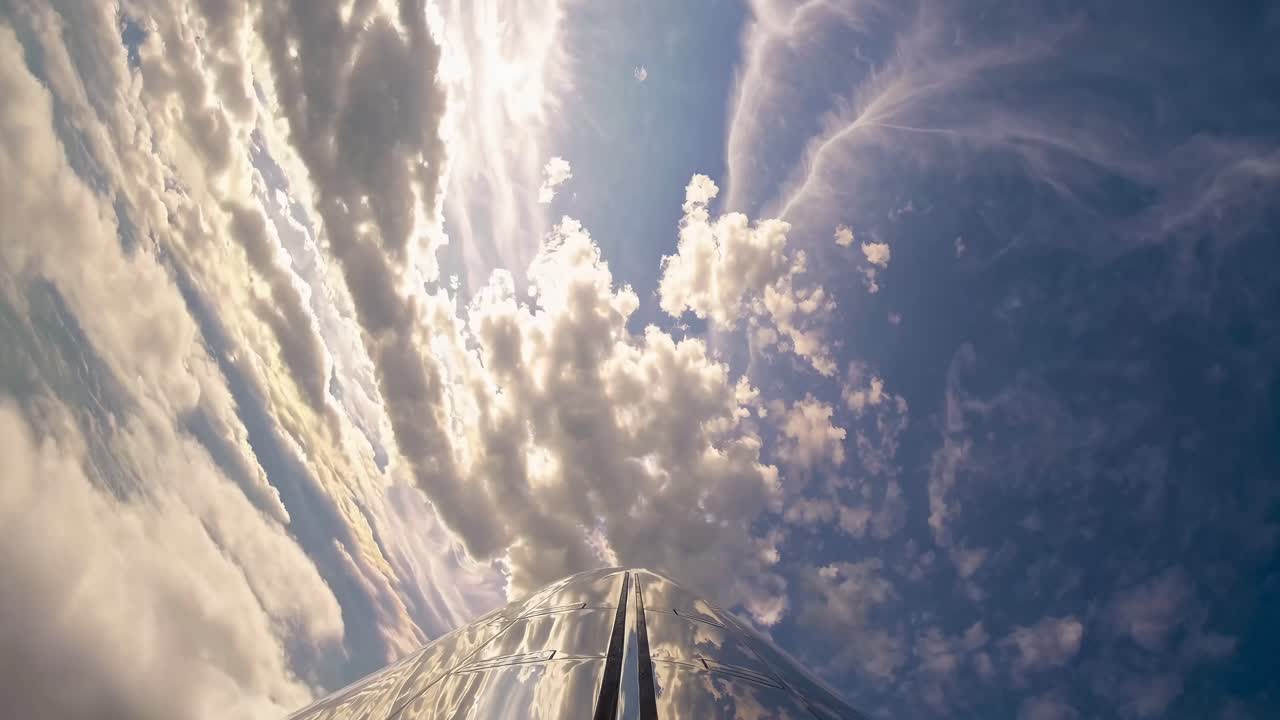 A dynamic video shot from a plane's nose, capturing a breathtaking upward angle of clouds and sky