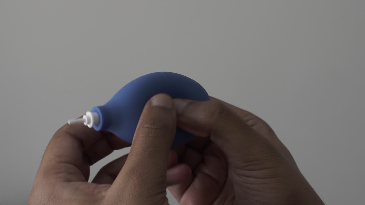 macho asiático adulto pulgares apretando la bomba del ventilador del ordenador azul como calmante para el estrés