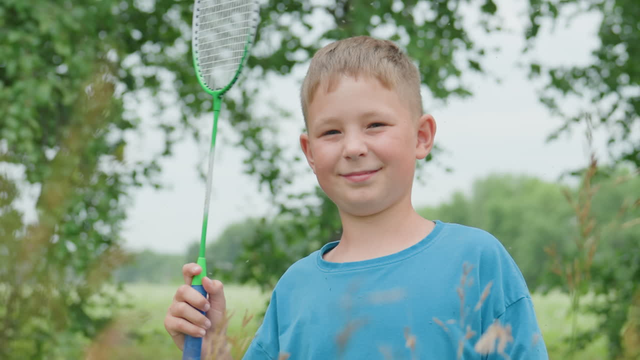 햇살이 비치는 초원에서 장난감 칼을 들고 파란색 셔츠를 입은 웃는 소년, 주변에는 자작나무와 키 큰 풀, 솔직한 미소와 클로즈업 인물 사진, 기사를 꿈꾸는 역할극, 진정한 어린 시절의 기쁨과 자연 속 야외