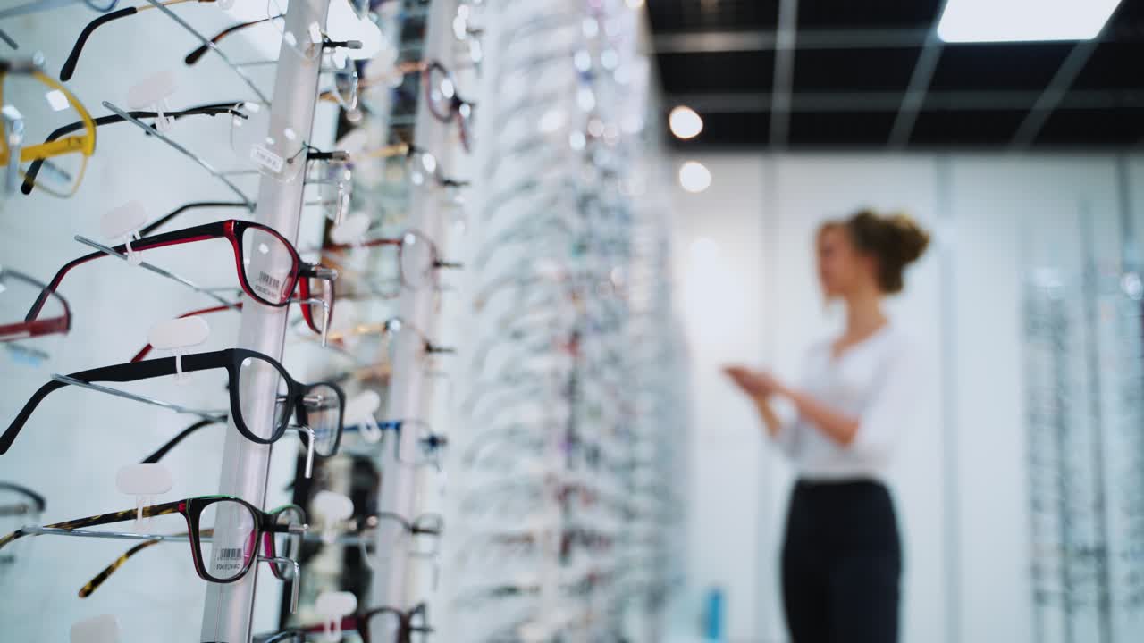 Woman buying new glasses. Woman trying on glasses, wants to buy in optician store