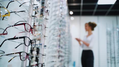woman buying new glasses. woman trying on glasses, wants to buy in optician store