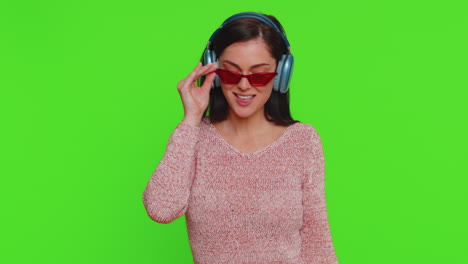 Young-happy-woman-in-headphones-listening-music-dancing-disco-having-fun-relaxing-on-christmas-party