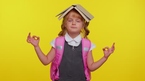 teenage girl in school uniform putting book on head, meditating, relaxing with concentrated thoughts