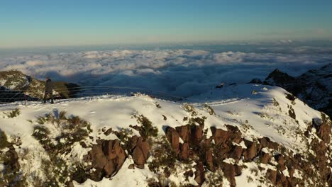 un hombre está solo tomando fotos en la cima de la montaña pico ruivo en madeira