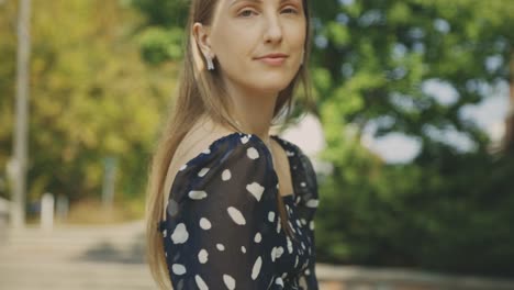 Relaxed-Woman-In-The-Park-Facing-The-Camera-With-A-Light-Smile-And-Holding-The-Ring-On-Her-Finger---Medium-Closeup