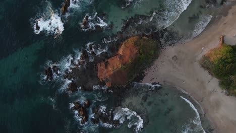 Slowly-descending-aerial-view-of-a-beautiful-rocky-beach