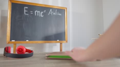 unrecognizable child closing laptop with chromakey screen. device with green screen on desk in classroom at school. wireless online education and modern technologies concept.