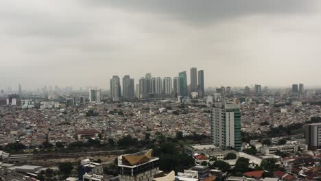 Toma-Cinematográfica-Del-Paisaje-Urbano-De-Yakarta-Con-Horizonte-Y-Vecindario-Denso-Durante-El-Día-Nublado