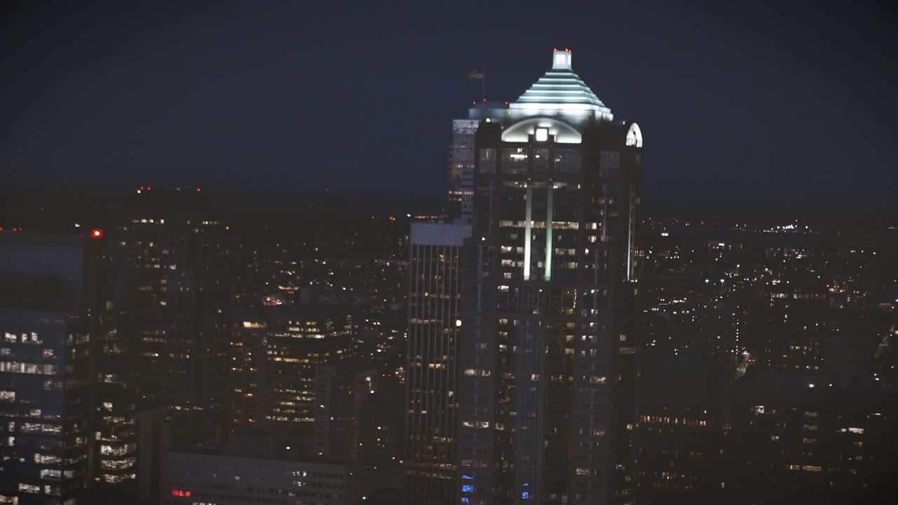 la parte superior de los edificios de rascacielos película de helicóptero nocturno