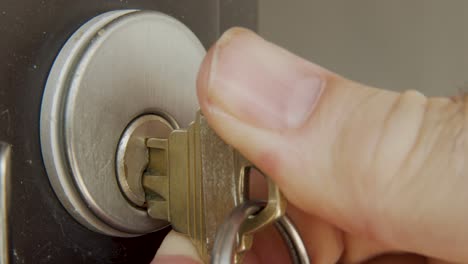 macro shot of inserting key into a lock and unlocking a door