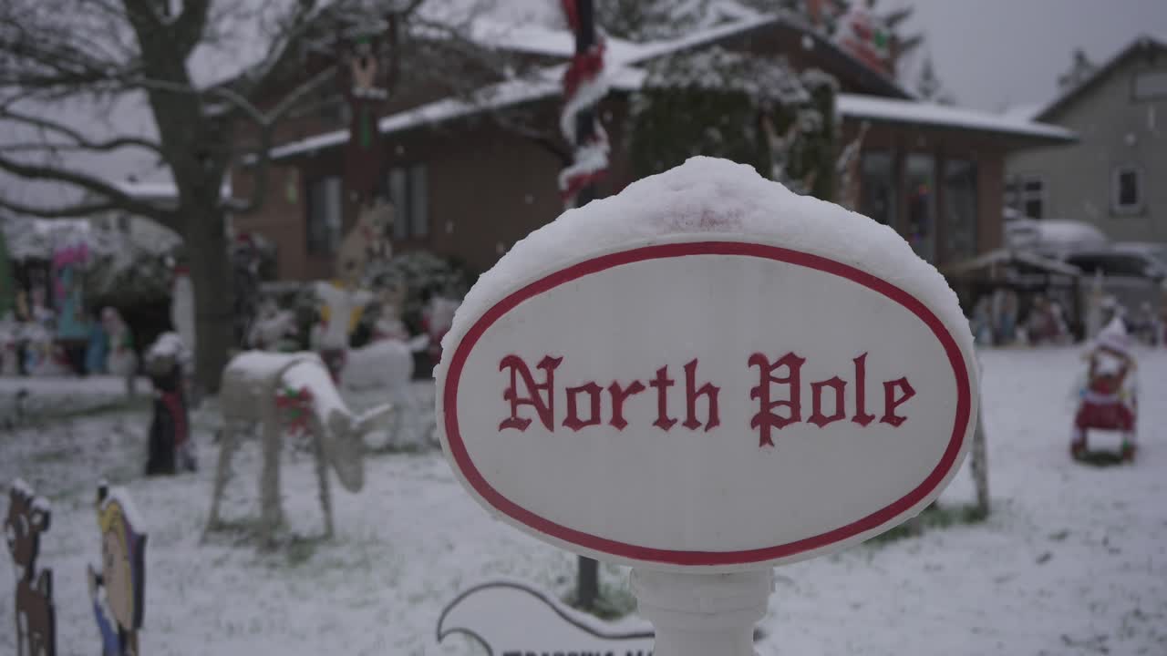 Christmas lawn decorations in a residential neighborhood during a light snowfall in Canada