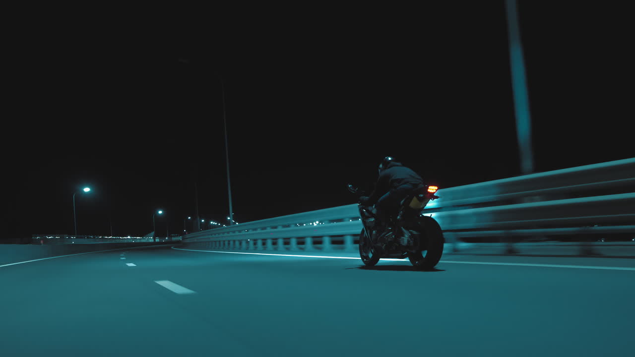 한 남자가 야간 트랙에서 스포츠 오토바이를 타고 있다