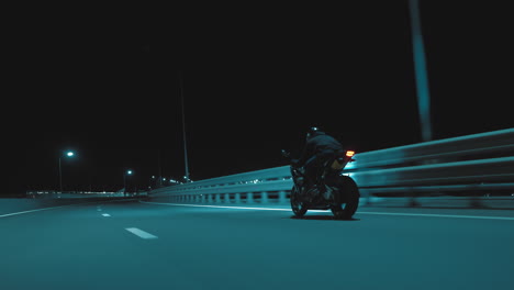 a man rides a sports motorcycle on a night track