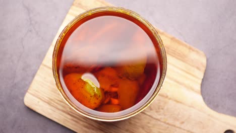 homemade mango pickle in a glass jar on table