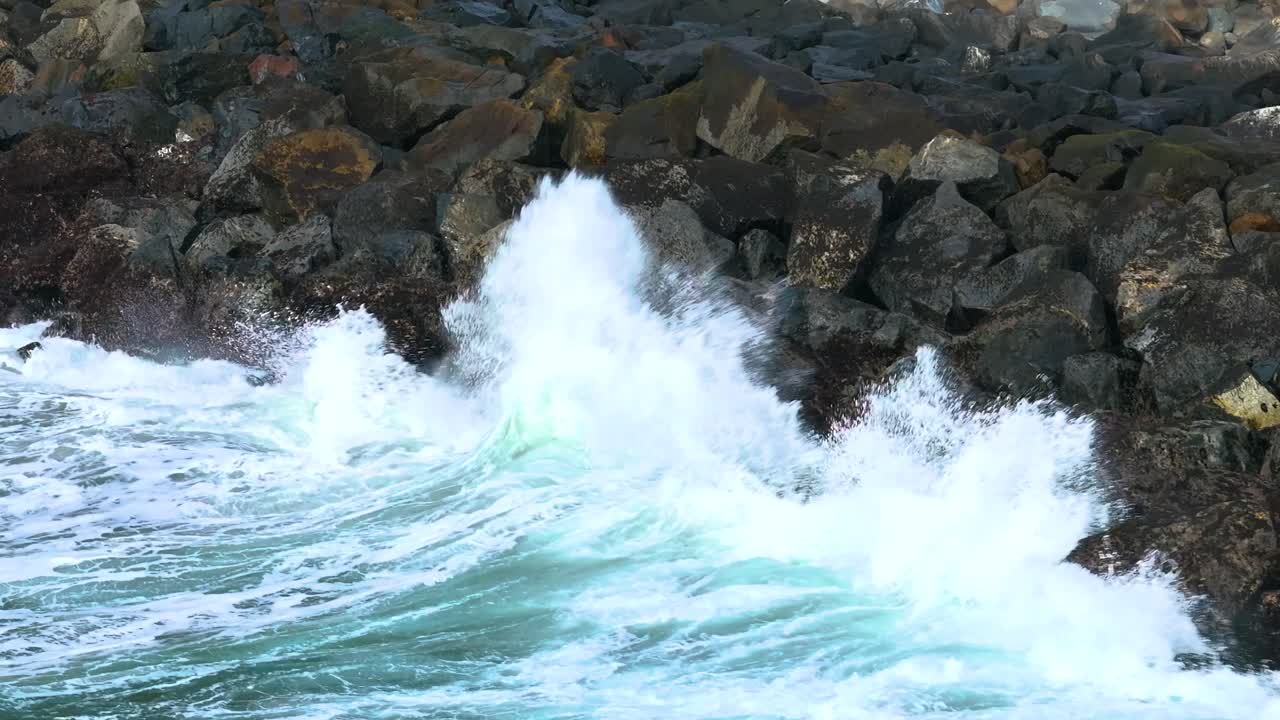 Aerial telephoto close up of crashing surf around base of Morro Rock on California’s rugged coastline