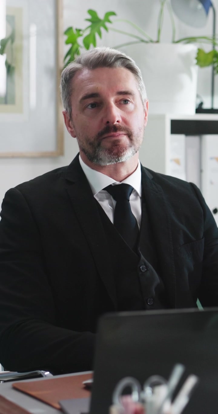Professional Businessman Sitting at Desk in Office