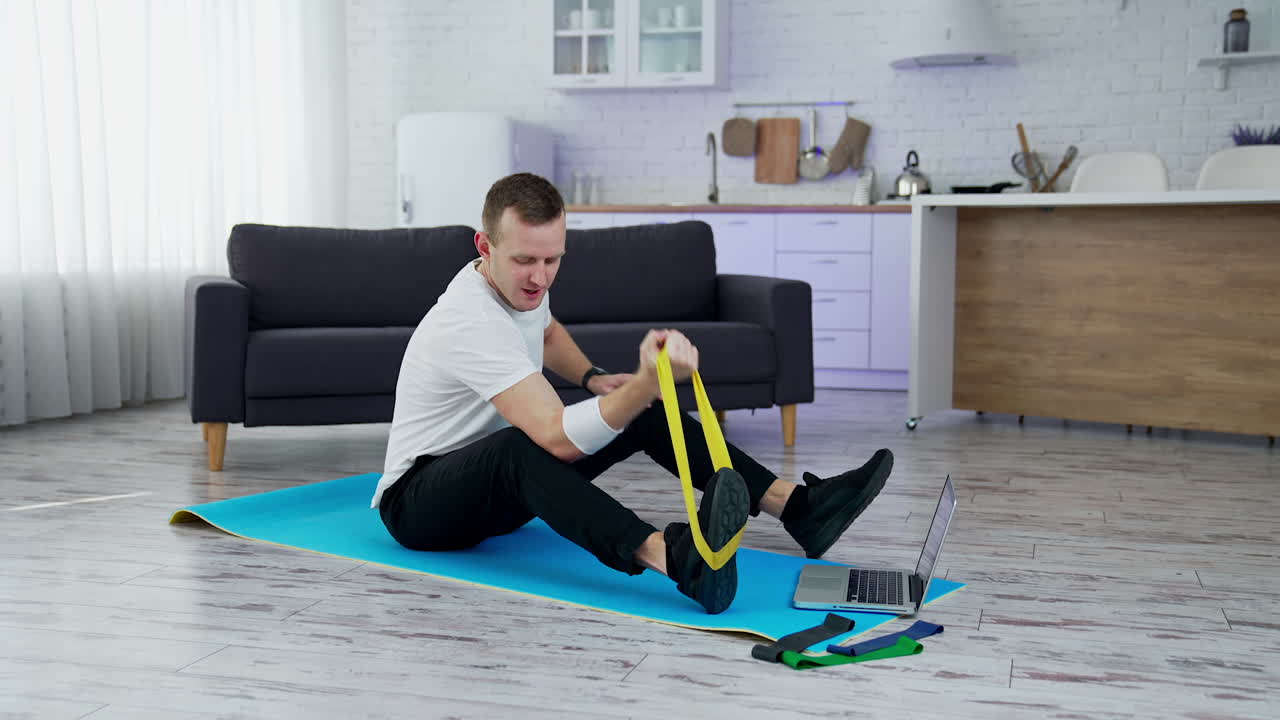 Training body indoor by strong handsome man. Young lifestyle sportsman working out at home.