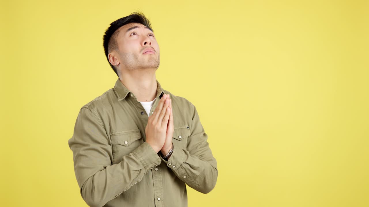Emotional Young Asian Man Praying or Pleading for Help