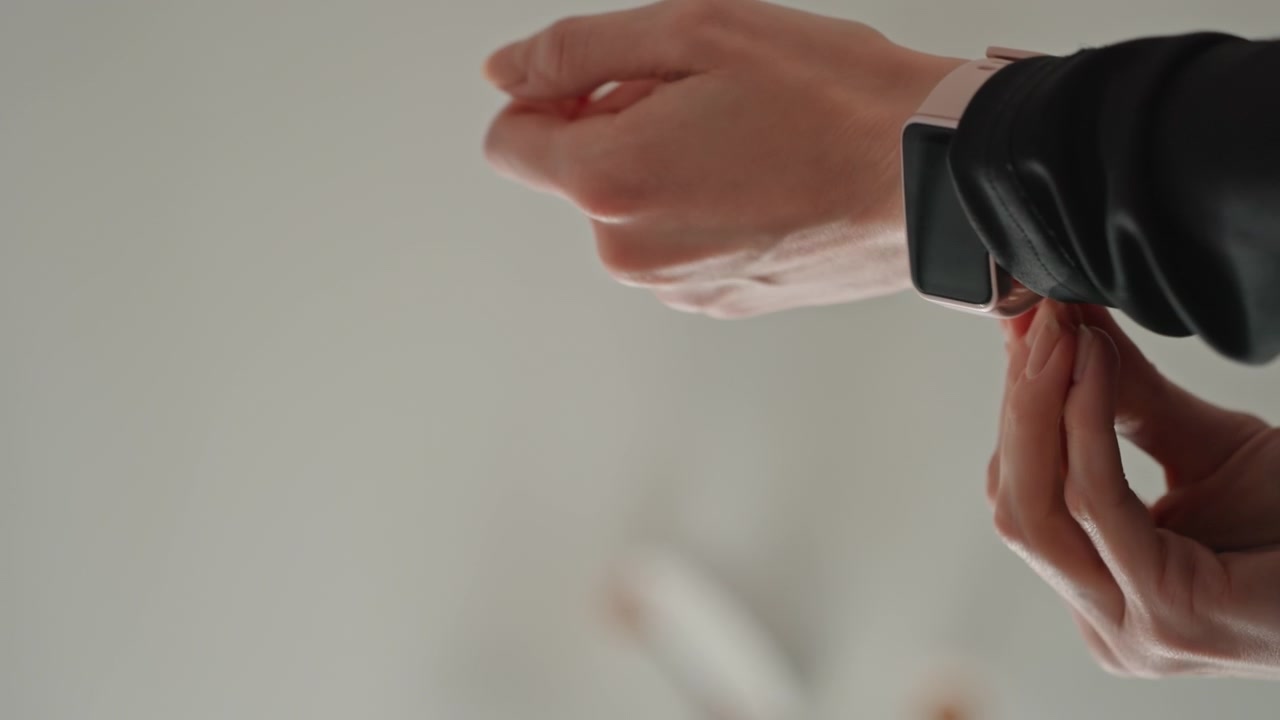 Woman reviews smartwatch. Preparing fitness device at home. Female prepares smartwatch for tech assessment at residence. Caucasian woman setting up smartwatch for review in her house