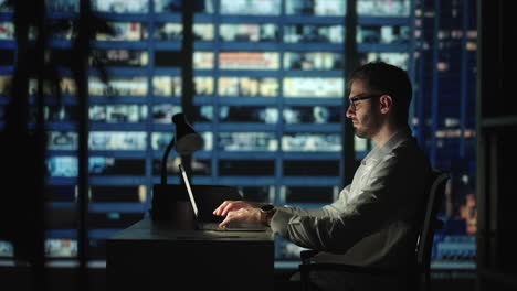 Retrato-De-Un-Hombre-De-Negocios-Exitoso-Y-Reflexivo-Que-Trabaja-En-Una-Computadora-Portátil-En-Su-Oficina-De-La-Gran-Ciudad-Por-La-Noche.-Carismático-Emprendedor-Digital-Realiza-Análisis-De-Datos-Para-Estrategia-De-Comercio-Electrónico.