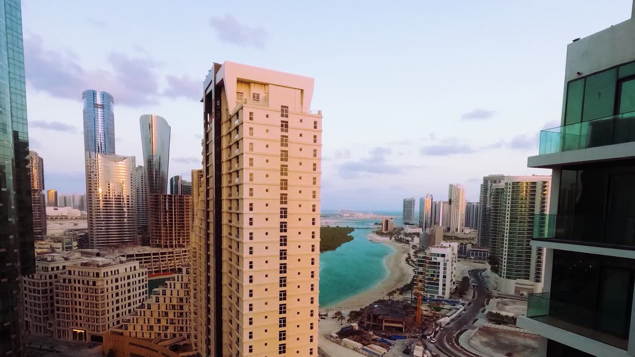 Alba ad Abu Dhabi sull'isola di Al Reem - paesaggio nuvoloso sul canale con vista sull'oceano, paesaggio urbano, time lapse.