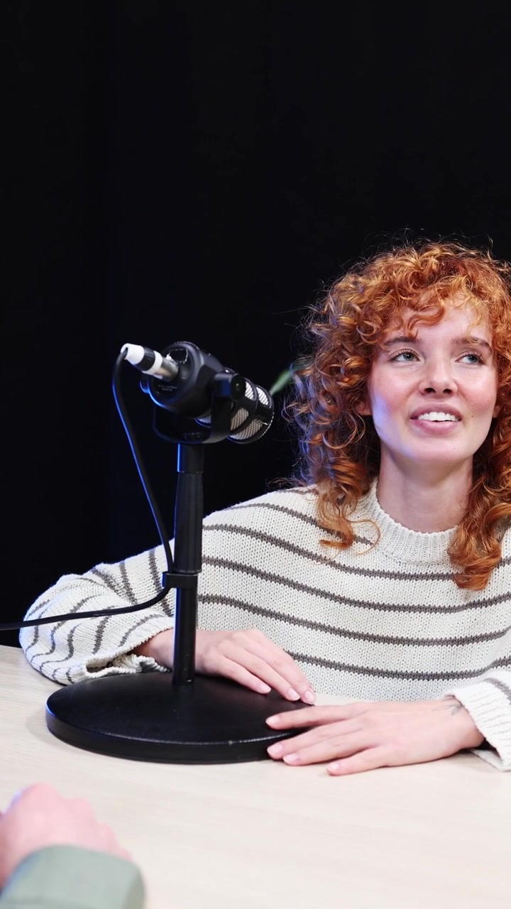 Young Woman with Curly Red Hair Talking During a Podcast Interview