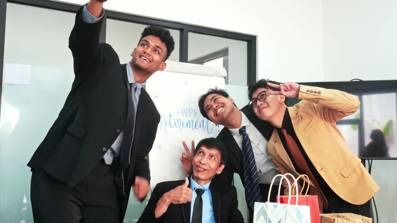 Joyful colleagues celebrate retirement with a fun selfie and festive gifts at modern office