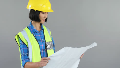 arquitecta mirando el plano contra un fondo gris 4k 4k