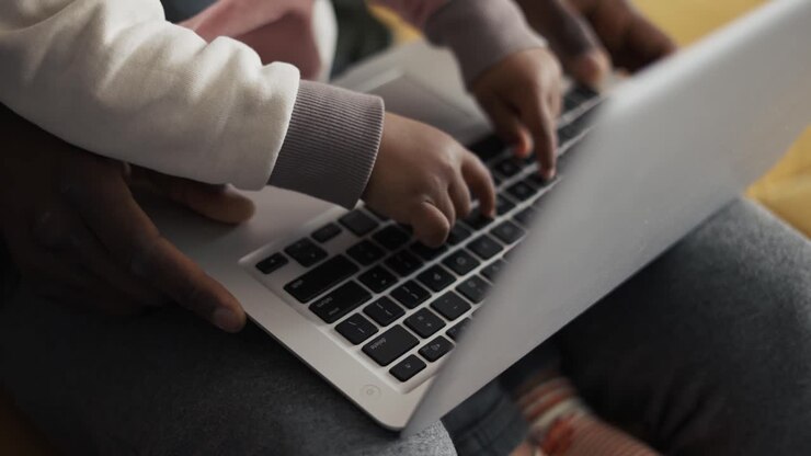 Padre afroamericano e bambino piccolo imparano a usare il computer a casa per l'educazione infantile.