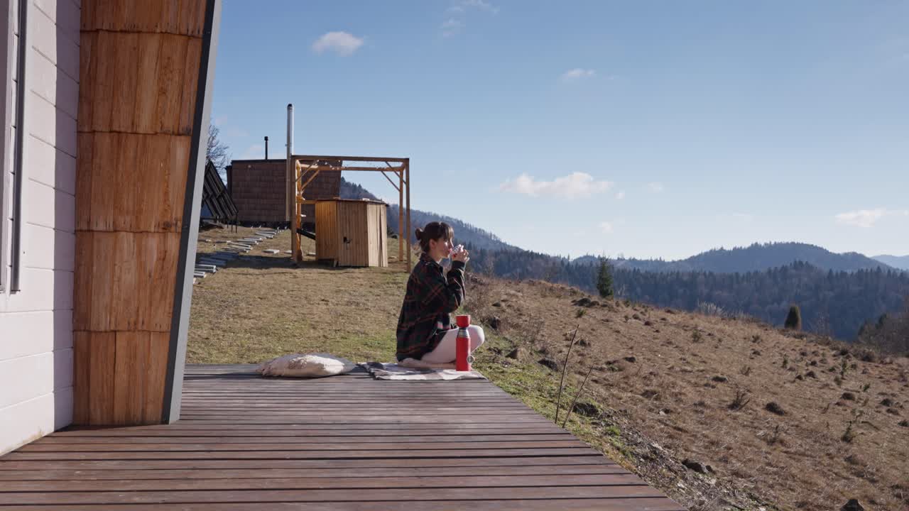 Woman Relaxing on Cabin Deck in the Mountains