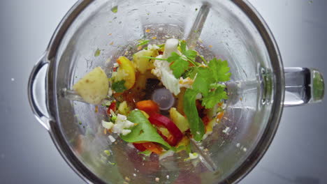 blender blades cutting vegetables in super slow motion. closeup veggies blending