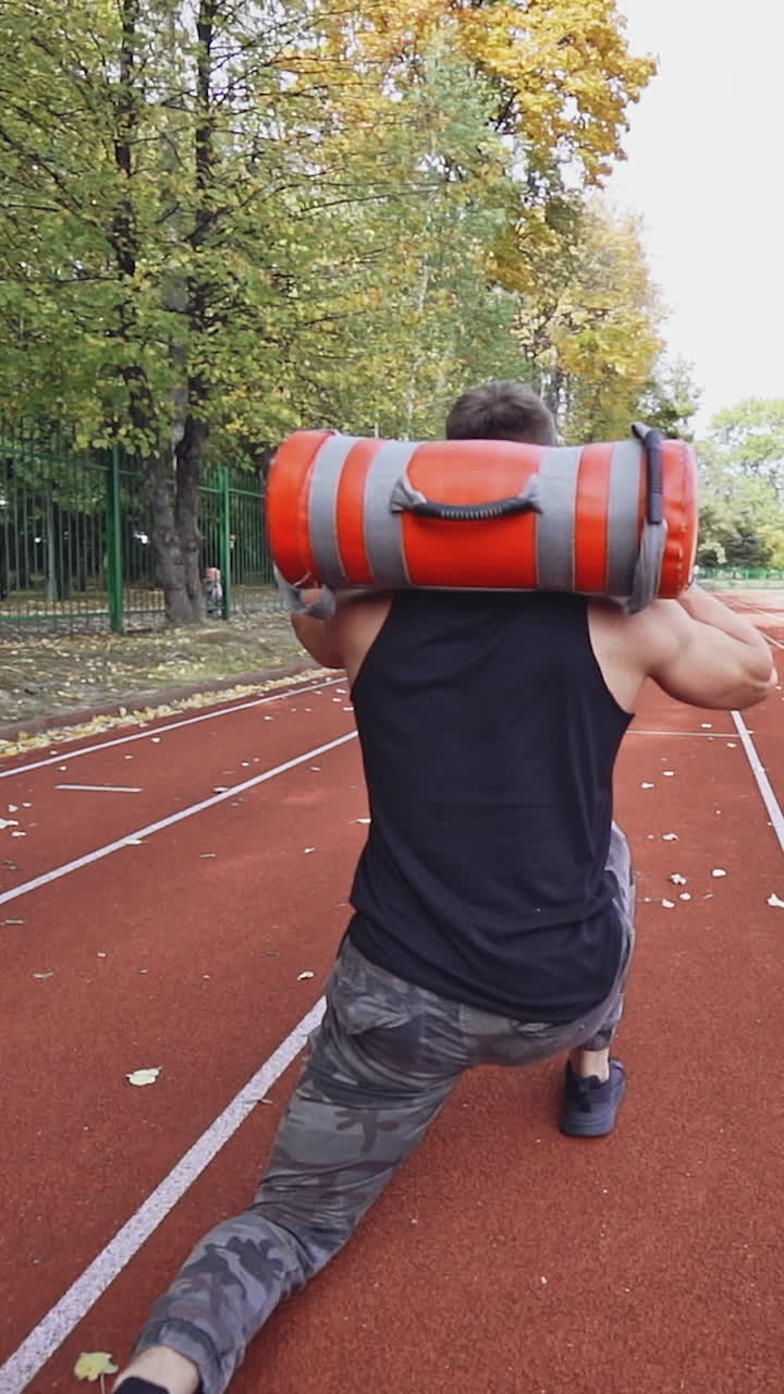 Young man exercising outdoors. Muscular built young athlete working out on stadium