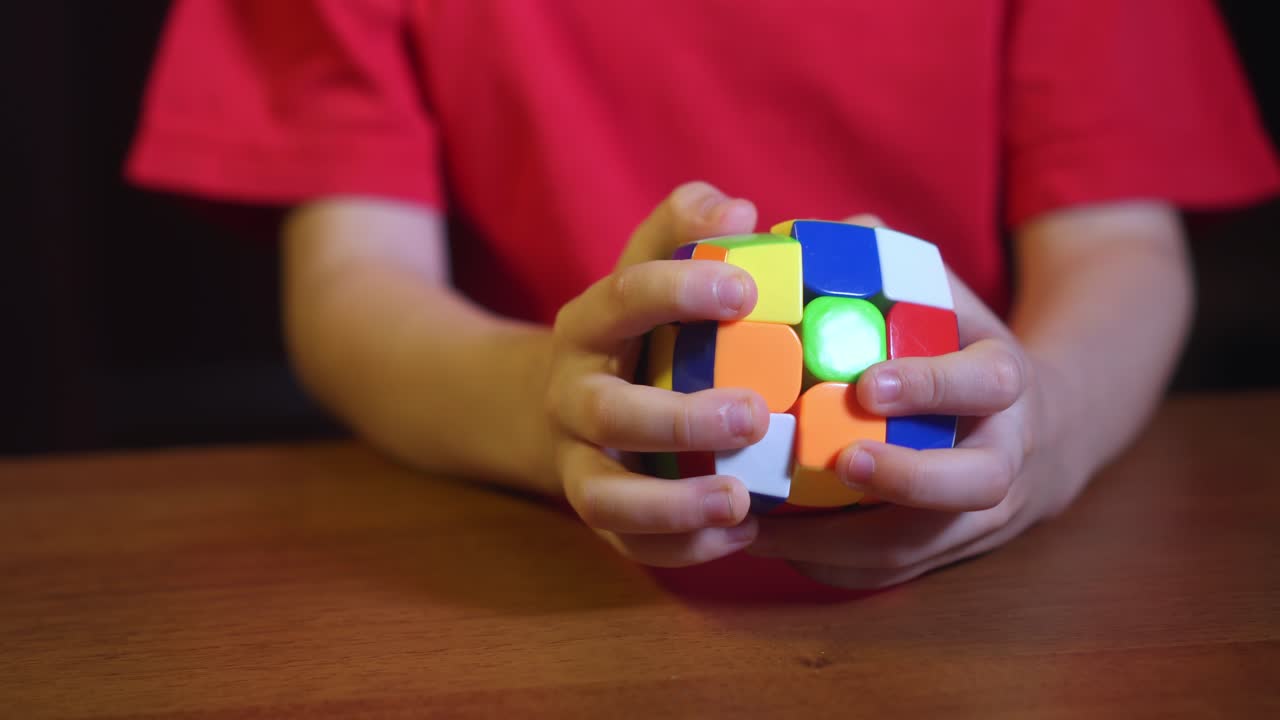 de cerca de niño pequeño juega una mente de desarrollo y el ingenio rápido juguete cubo de rubik