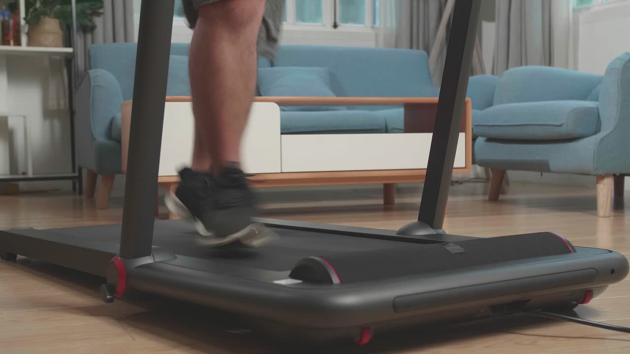Legs Of Asian Fat Man Running On A Treadmill At Home