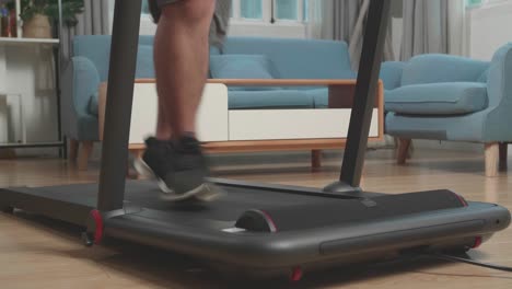 legs of asian fat man running on a treadmill at home