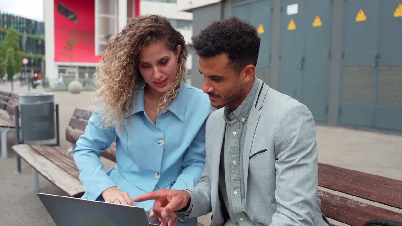 Business Colleagues Collaborating on a Laptop Outdoors