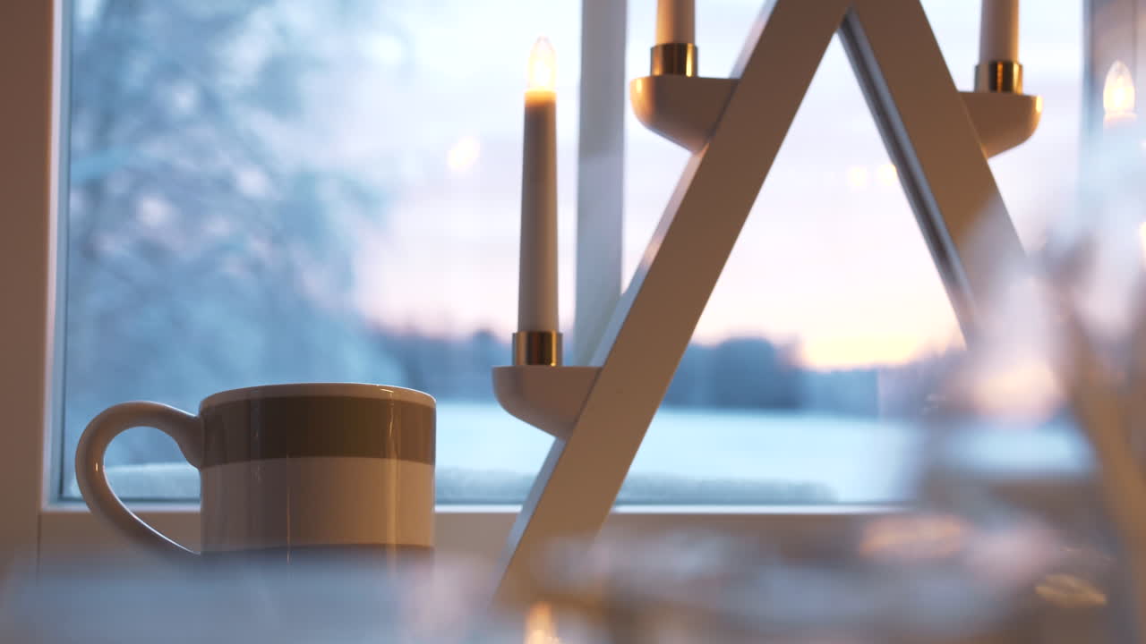 창에서 크리스마스 시간 장식 램프로 컵의 느린 팬 클로즈업