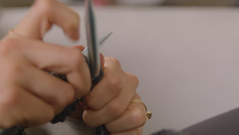 Woman-knitting-with-grey-wool.-Close-up