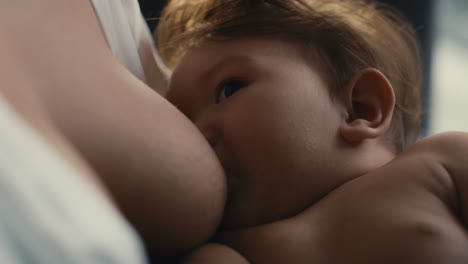 primer plano de un bebé asiático amamantado por su madre