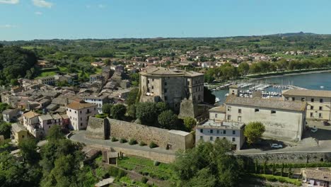 aerial around the rocca farnese castle and old town of capodimonte on lake bolsena, province of viterbo, italy