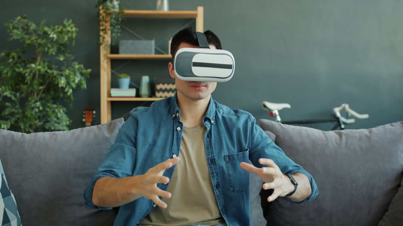Uomo che usa le cuffie VR a casa