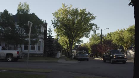 Luftpanorama-Von-Einem-Haus-Im-New-England-Stil-Mit-Vintage-Charakter-Und-Überqueren-Der-Straße-Mit-Geparkten-Autos-Ohne-Nummernschilder-An-Ihren-Vorderen-Stoßstangen-An-Einem-Frühen-Sommermorgen,-Wenn-Die-Sonne-Aufgeht